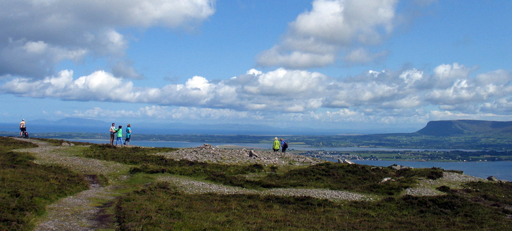 A group visiting the ruined passage-grave called Knocknarea North on the summit of Knocknarea in County Sligo.