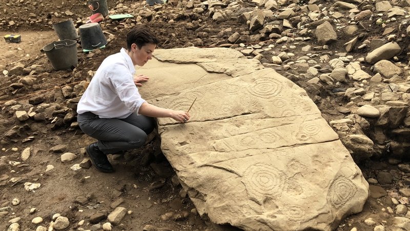 Dr. Clíodhna Ní Lionáin examins the newly discovered panel of neolithic art discovered under Dowth Hall.
