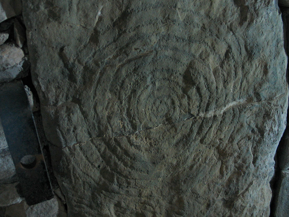 A large spiral carved on the left side of the passage close to the entrance of Knowth east.