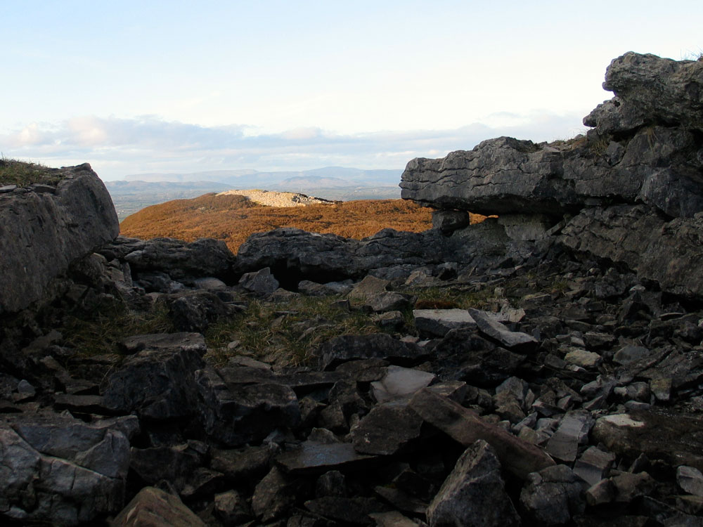 Looking north from the ruined chamber of Cairn F, across Cairn E.