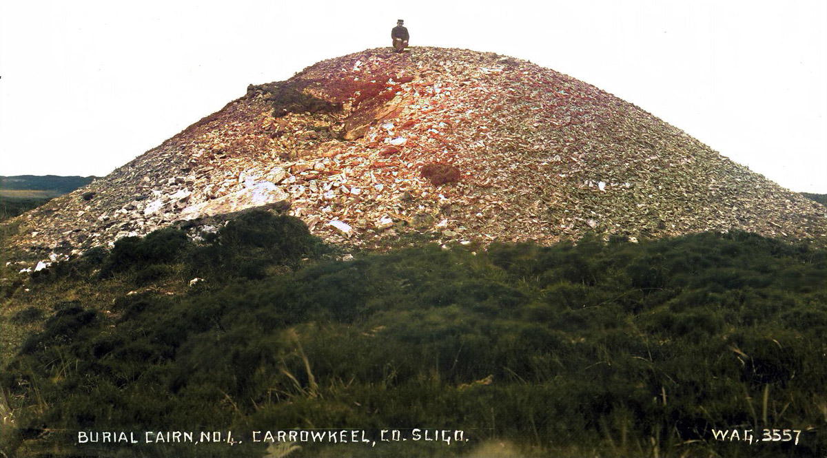 Praeger sitting on Cairn F before the excavations began in 1911.