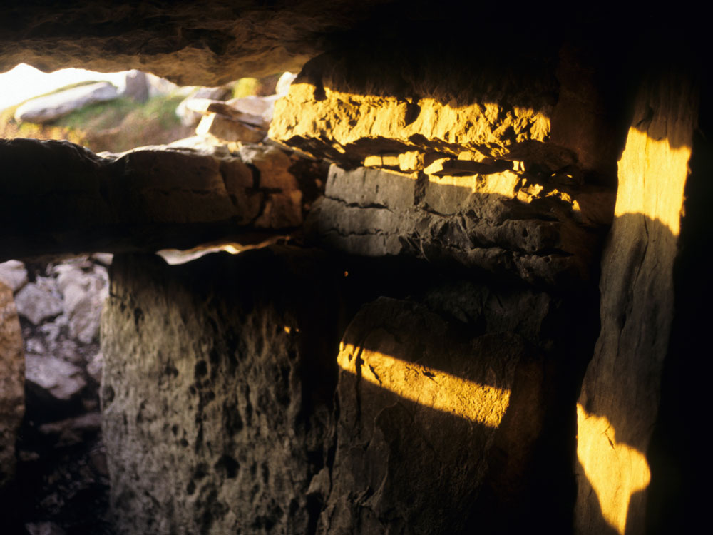 Sunset
        on the summer solstice enters Cairn G through the roofbox.
        The sun can shine into this monument for about 6 weeks on either side
of midsummer.