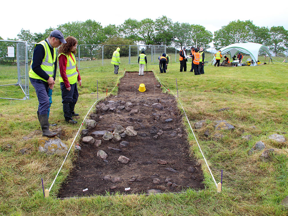 Marion Dowd and a Guide examine the trench in 2019.