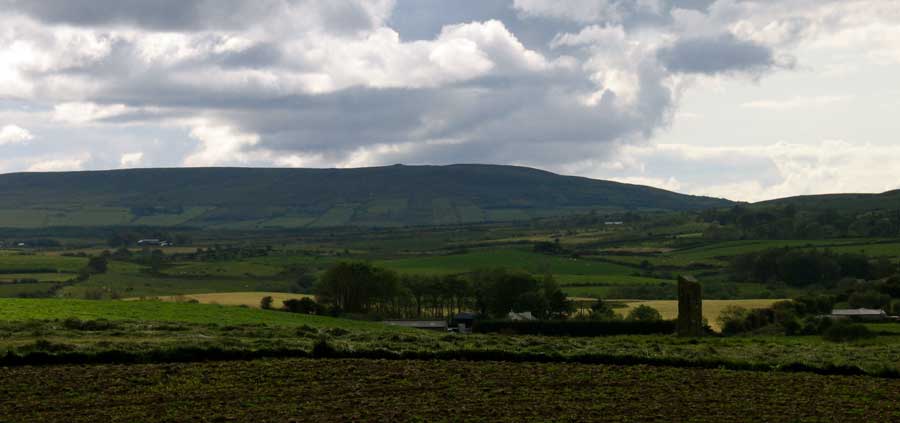 The
    imposing Breastagh Ogham Stone. Shreeloga Hill can be seen in the distance.