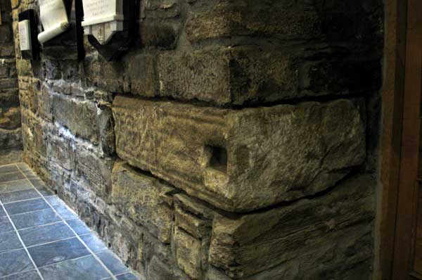 The shaft of a large high cross built into the west wall of the modern church at Drumcliffe