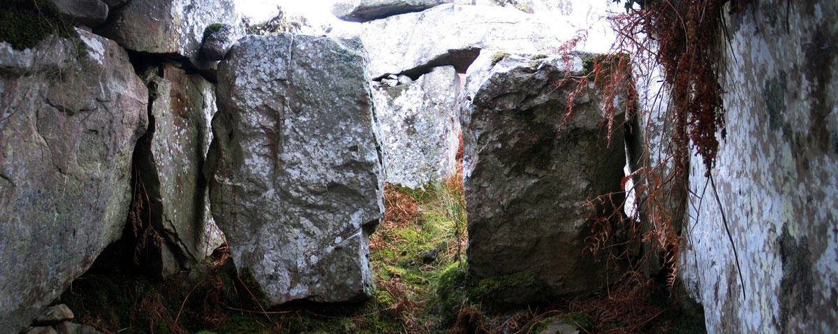 Looking south past the cist or external chamber built into the west arm of the court at Croaghbeg court tomb.