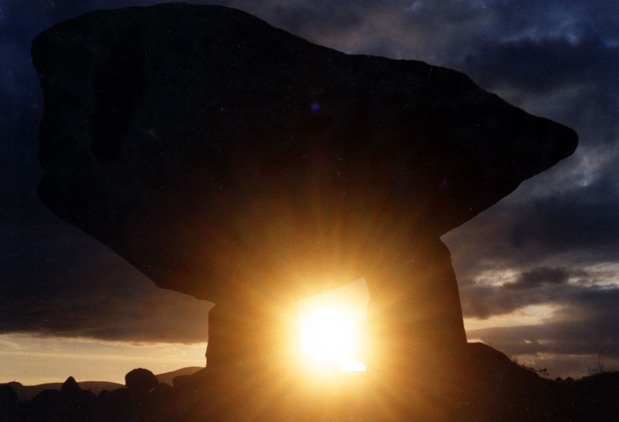 A dramatic photo of the winter solstice sunset shining through the Kilclooney dolmen.
