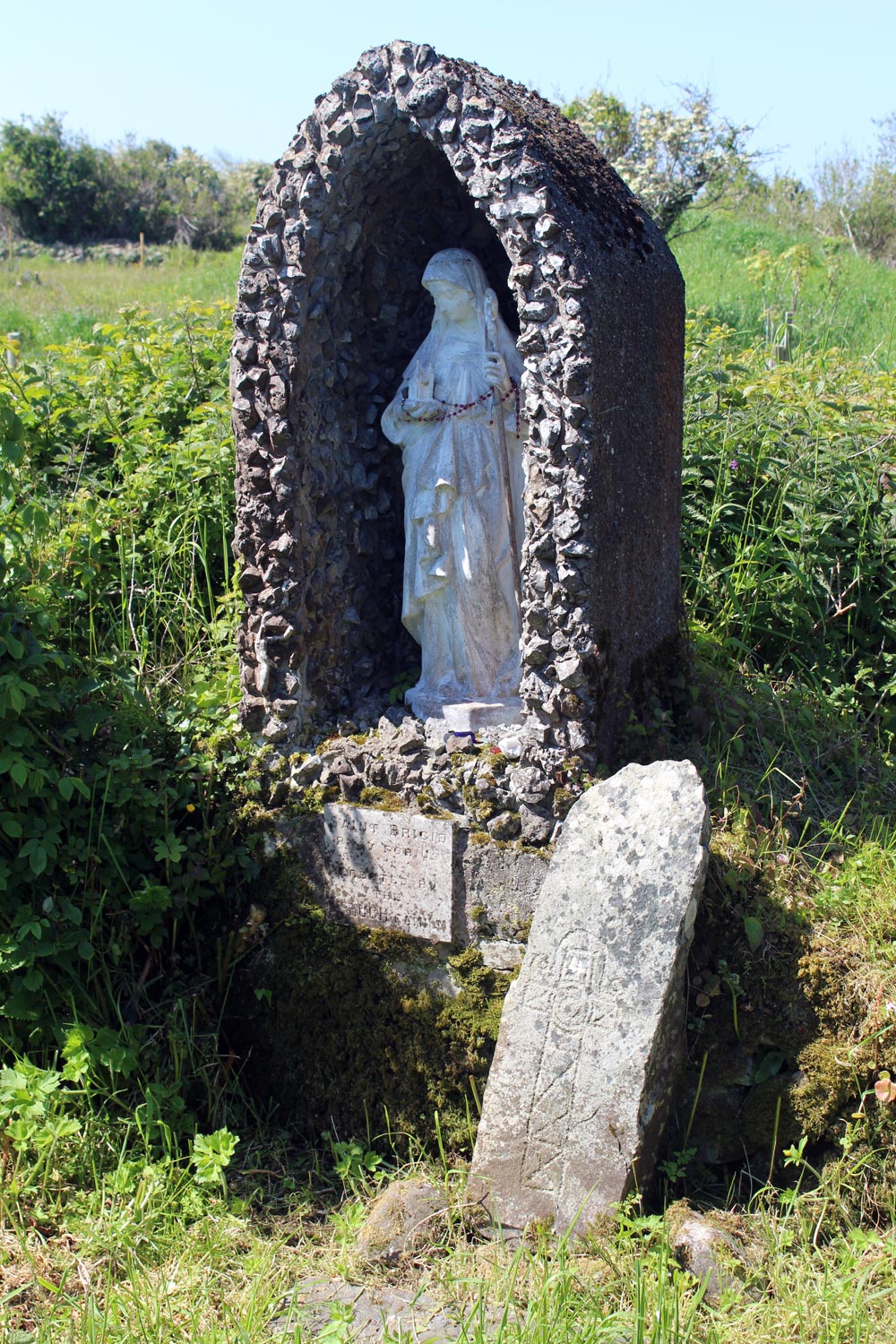 The early Christian cross-slab and modern statue of Saint Brigit.